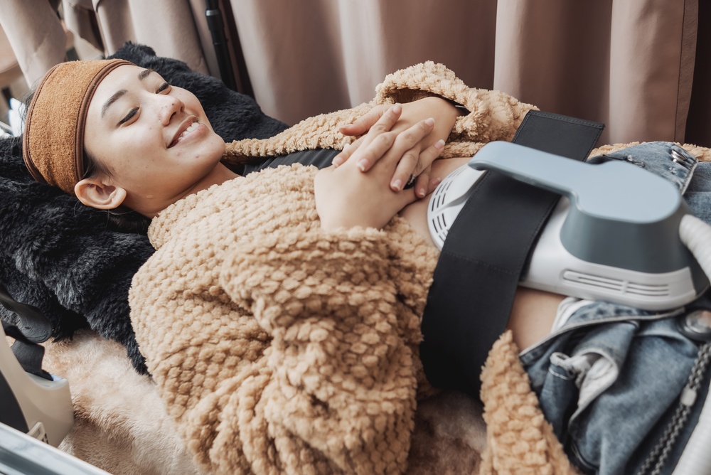 woman using Emsculpt on her midsection in Arlington VA